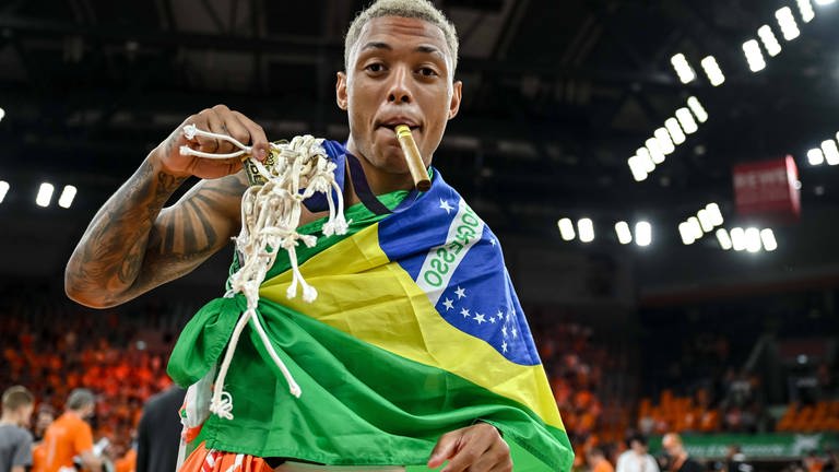 So feiert ein Brasilianer: Yago Dos Santos mit den Überresten eines Basketball-Korbes, mit Zigarre und Brasilien-Flagge. (Foto: IMAGO, IMAGO | Langer)