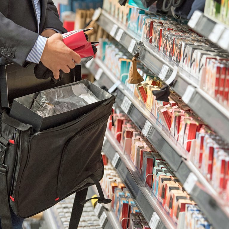 Ein Mann steckt Ware in seine Tasche: Ladendiebstahl im Supermarkt, Discounter und Baumarkt hat wieder stark zugenommen.