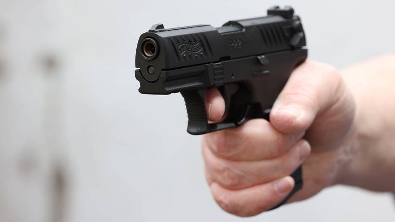 Pistole in der Hand eines Mannes. In Biberach soll ein Lkw-Fahrer auf einen Autofahrer geschossen haben. Die Polizei sucht nun Zeugen. (Symbolbild) (Foto: IMAGO, IMAGO / Rene Traut)