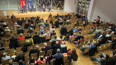 Eine sitzende Reihe von Frauen und Männern auf einer Bühne in einem Saal. Rund 250 Besucherinnen und Besucher verfolgten die Podiumsdiskussion des SWR und der Landeszentrale für politische Bildung zur OB-Wahl in Ulm.  (Foto: SWR, Monika Götz)