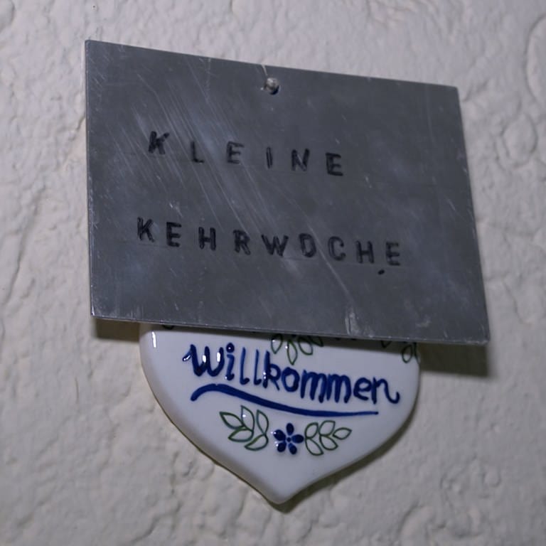 Ein Schild mit der Aufschrift "Kleine Kehrwoche". Die Kehrwoche in vielen Mietshäusern in Aalen wird abgeschafft, deshalb hängt dieses Schild vor den Haustüren der Wohnungsbau Aalen bald nicht mehr. (Foto: SWR, Frank Polifke)