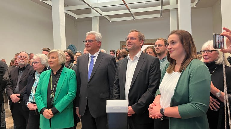 Drei von fünf Kandidierenden beobachten das Ergebnis der OB-Wahl 2023 im Rathaus in Ulm. 