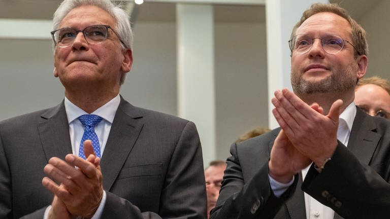 Gunter Czisch (CDU, l), Oberbürgermeister von Ulm, steht im Rathaus applaudierend neben seinem designierten Nachfolger Martin Ansbacher (SPD).
