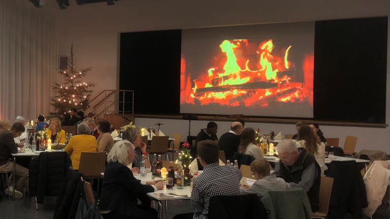An gemütlichen Tischen in der Stadthalle Heubach feiern Menschen Heiligabend gemeinsam statt einsam