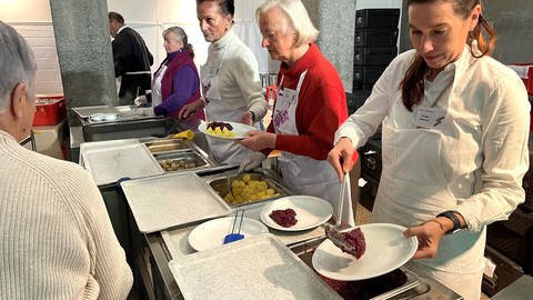 Ehrenamtliche Mitarbeiter helfen bei der Essensausgabe: In der Pauluskirche in Ulm hat am Donnerstag die 29. Vesperkirche begonnen. Vier Wochen lang erhalten Bedürftige eine warme Mahlzeit. 