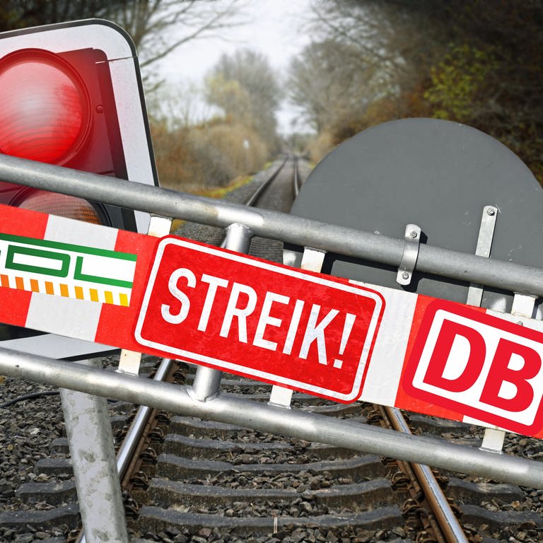 Schranke mit Aufschrift Streik, DB und GDL vor leeren Bahnschienen und rotes Haltesignal. (Symbolbild)
