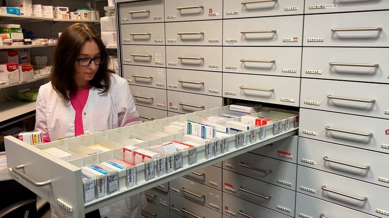 Nataliia Zeikan steht vor einem Medikamenten Schrank. Die Geflüchtete aus der Ukraine hat über das Jobcenter Ostalbkreis eine Anstellung in einer Apotheke bekommen. (Foto: SWR)