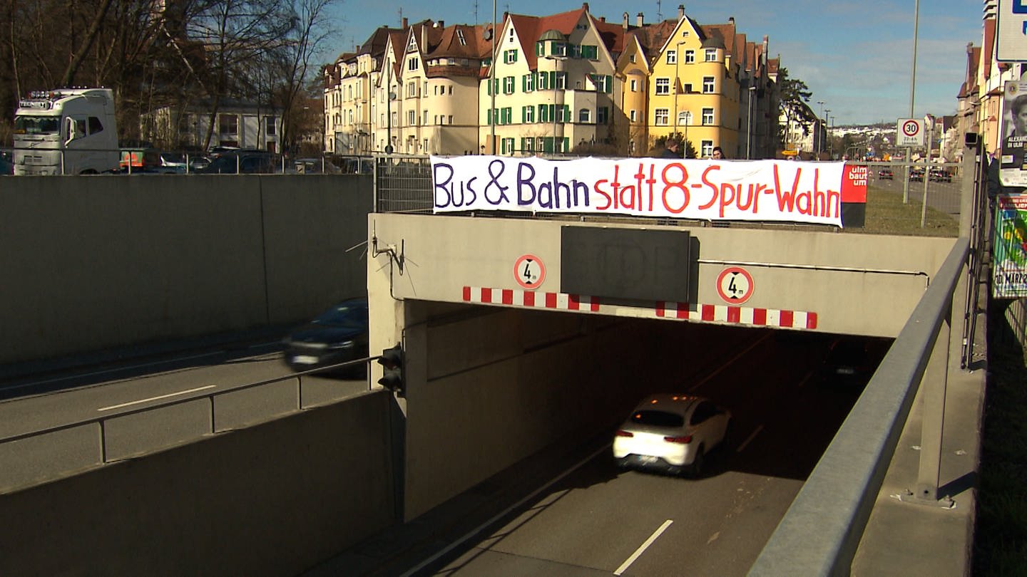 Ein Banner hängt über einer Tunneleinfahrt. 30 Menschen haben am Sonntagnachmittag am Tunnel der B28 in Ulm für eine schnelle Verkehrswende protestiert. (Foto: SWR, Frank Wiesner)