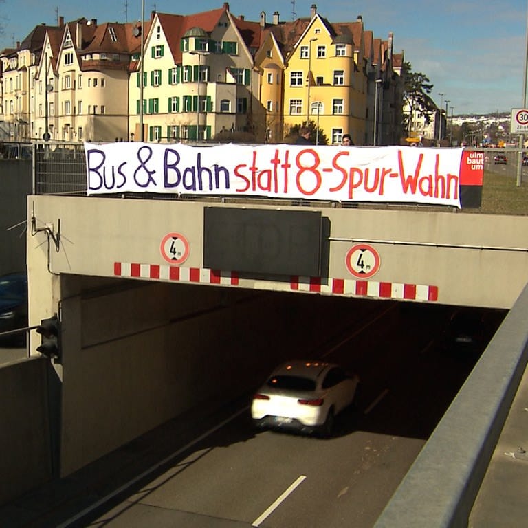 Ein Banner hängt über einer Tunneleinfahrt. 30 Menschen haben am Sonntagnachmittag am Tunnel der B28 in Ulm für eine schnelle Verkehrswende protestiert.  (Foto: SWR, Frank Wiesner)