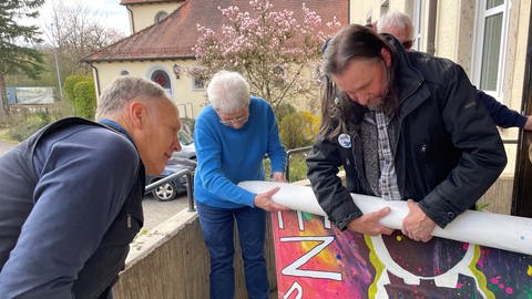Mitglieder des Aktionsbündnisses aus Ellwangen zeigen ein buntes Transparent mit der Aufschrift "Frieden machen!" und sind bereit für den Ostermarsch 2024. (Foto: SWR)