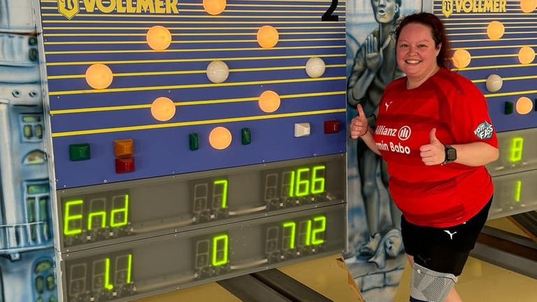 Sportkeglerin Kathrin Lutz aus Ellwangen posiert vor der Punktzahl ihrer Weltbestleistung. Als erste Frau knackt sie im Kegeln die 700 Punkte in einem Wettkampf.