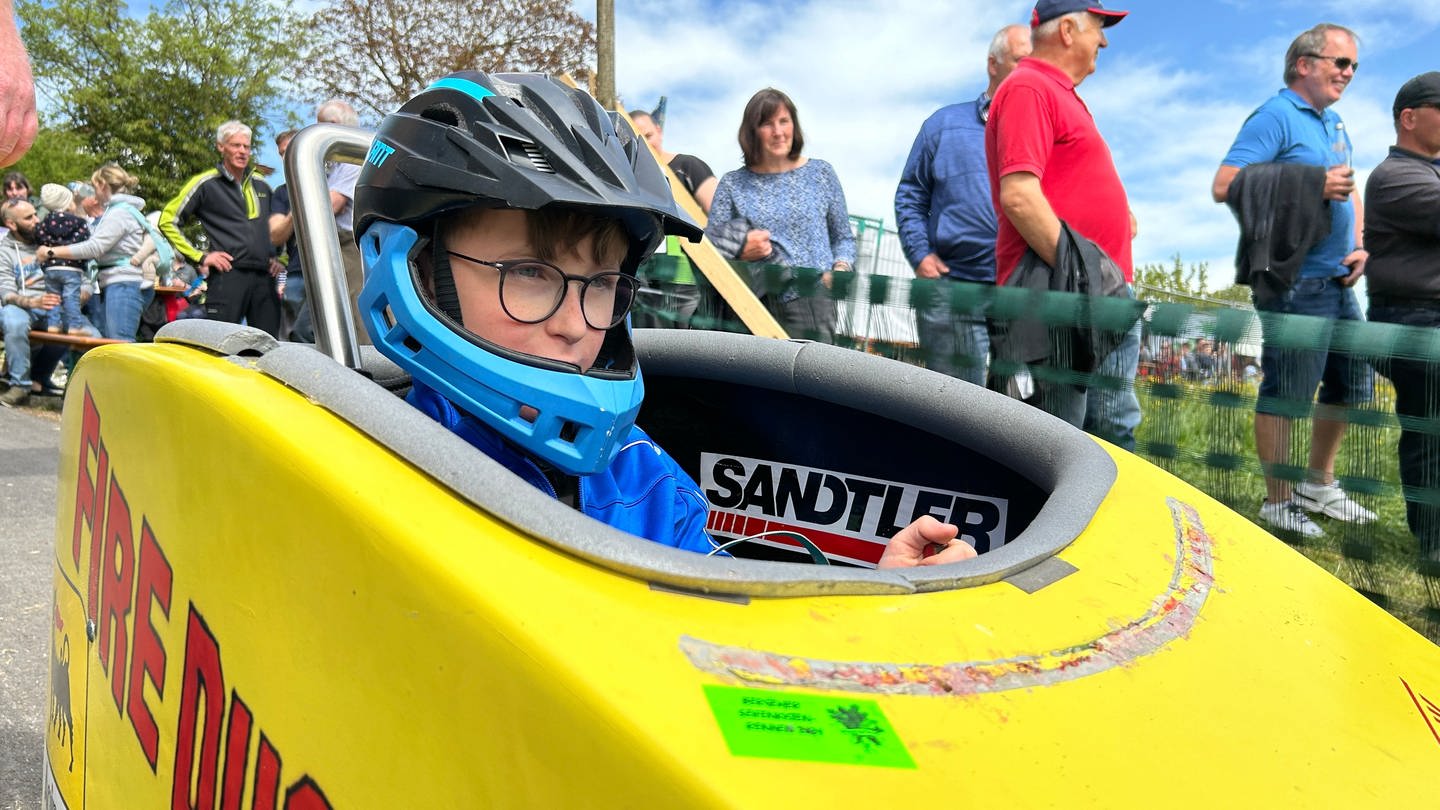 Der 10-jährige Julius Nagel sitzt in seiner Seifenkiste am Start eines Seifenkistenrennens. (Foto: SWR)