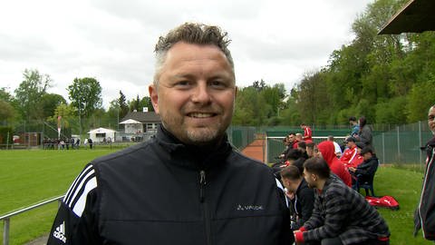 Der gut gelaunte Abteilungsleiter Christian Heussner vom TSV Regglisweiler blickt beim Interview mit dem SWR lachend in die Kamera. 