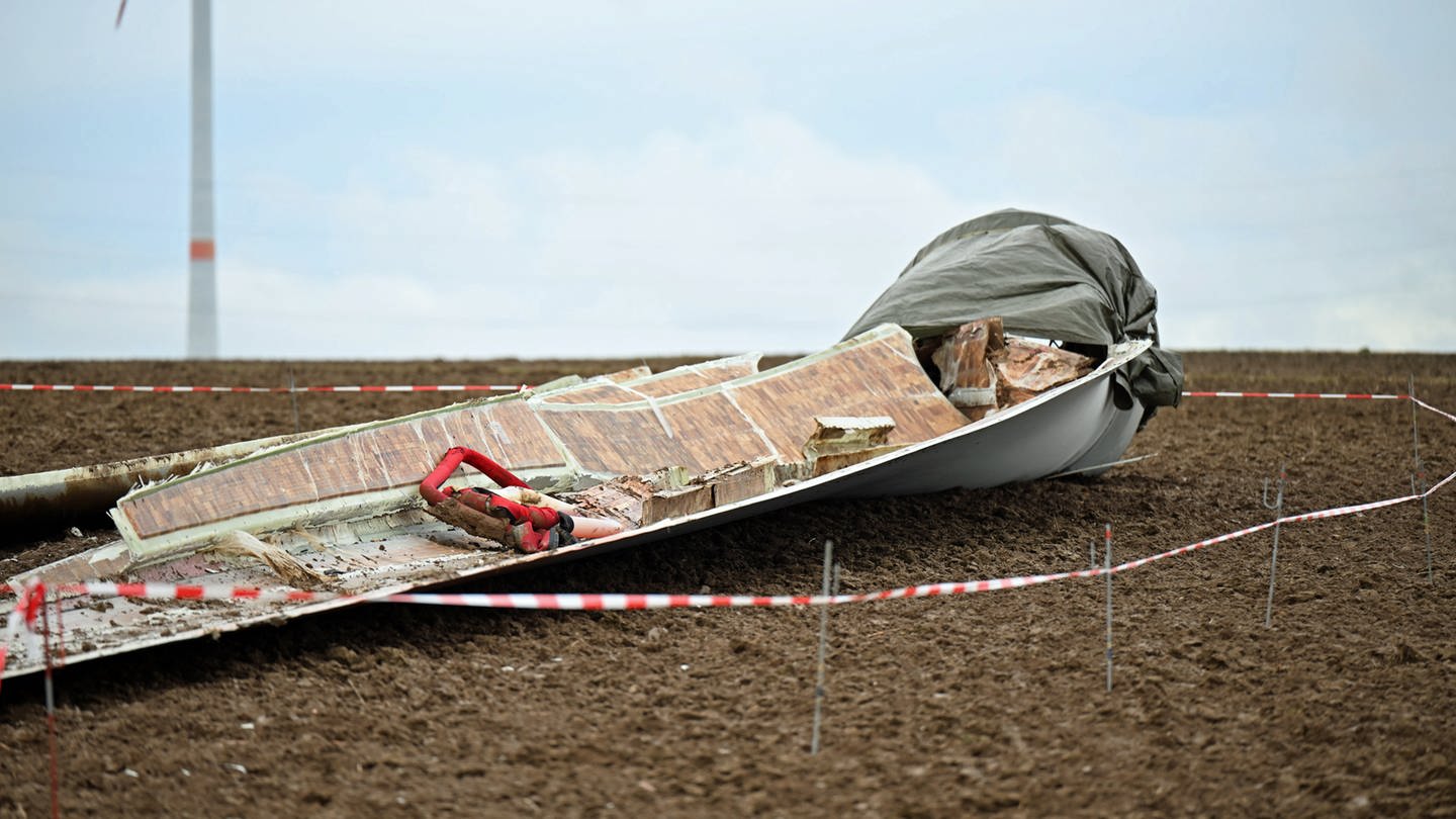 Die Reste eines 40 Meter langen und tonnenschwere Windradflügels liegen auf einem Feld. Jetzt steht die Ursache des Vorfalls fest. (Foto: dpa Bildfunk, picture alliance/dpa | Marius Bulling)