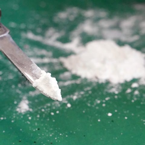 Weißes Pulver auf einer Messerspitze: Polizeibeamte haben bei Kontrollen auf der A7 bei Illertissen (Kreis Neu-Ulm) und Berkheim (Kreis Biberach) insgesamt 28 Kilogramm Kokain sichergestellt.
