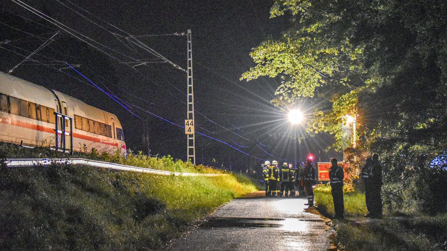 Einsatzkräfte stehen am Abend an der Bahnlinie bei Schwäbisch Gmünd, neben Waggons eines ICE, der nach einem Erdrutsch entgleist ist. (Foto: dpa Bildfunk, picture alliance/dpa/onw-images | Fabian Koss)