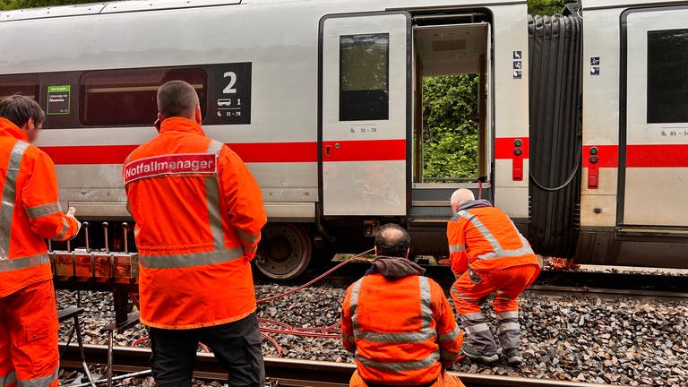 Bahnmitarbeiter untersuchen einen bei Schwäbisch Gmünd entgleisten ICE.