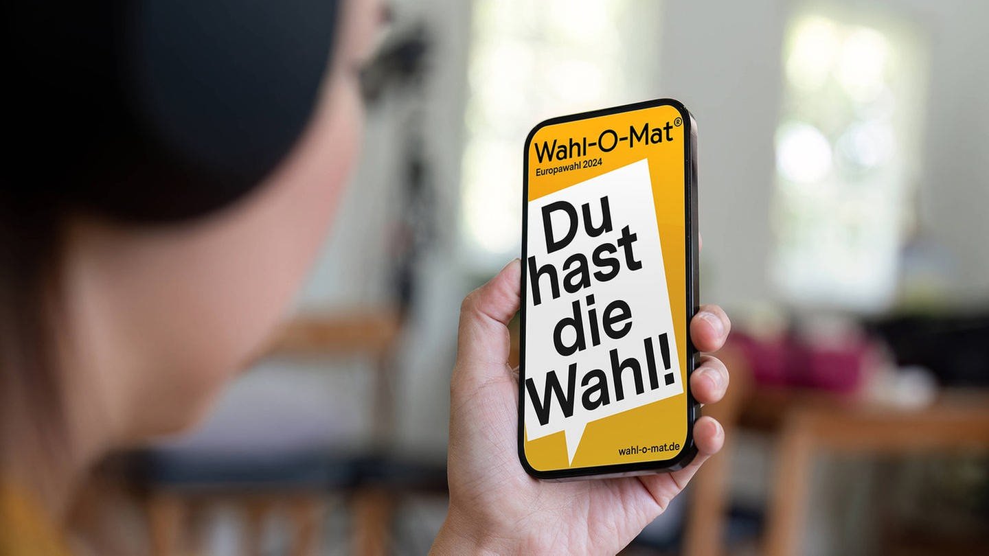 Europawahl 2024 Wahl-O-Mat ist online: Hand hält Smartphone mit Wahl-O-Mat-App (Foto: IMAGO, Zoonar)