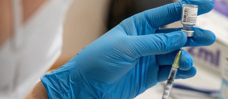 Hand in blauem Gummihandschuh hält eine Impf-Spritze (Foto: dpa Bildfunk, picture alliance/dpa | Sebastian Gollnow)
