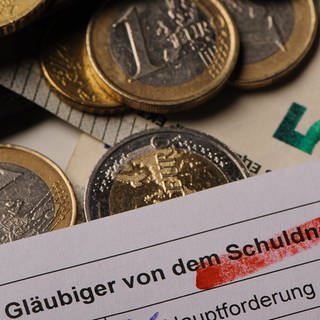 Geld und ein Schuldner-Formular. (Foto: dpa Bildfunk, picture alliance/dpa | Swen Pförtner)