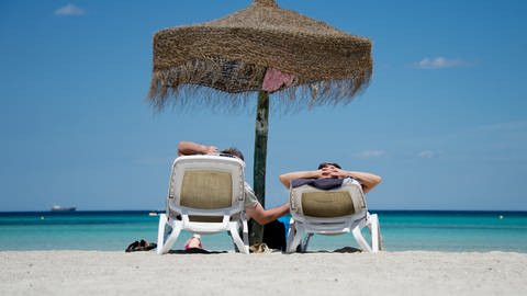 Deutsche Urlauber liegen an einem Strand im Norden der Mittelmeerinsel Mallorca. (Foto: dpa Bildfunk, picture alliance/dpa | Julian Stratenschulte)