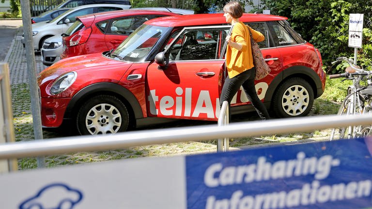 Eine junge Frau steigt an einer Carsharing-Station in einen roten Mini ein. (Foto: dpa Bildfunk, picture alliance / Jan Woitas/dpa-Zentralbild/dpa | Jan Woitas)