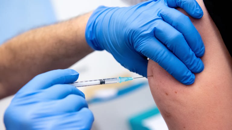 Ein Mitarbeiter der Asklepios Klinik wird von einem Kollegen mit dem Corona-Impfstoff von BiontechPfizer geimpft. (Foto: dpa Bildfunk, Picture Alliance)