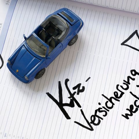 Ein Modellauto steht auf einem Kalenderblatt vom 30. November - zu lesen ist: "Kfz-Versicherung wechseln!" (Foto: dpa Bildfunk, picture alliance / dpa | Peter Kneffel)
