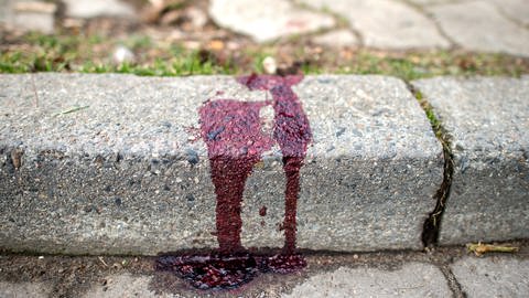 Nach einem Messerangriff auf eine Frau klebt Blut an einem Bordstein (Foto: dpa Bildfunk, picture alliance/ dpa/ Hauke-Christian Dittrich)