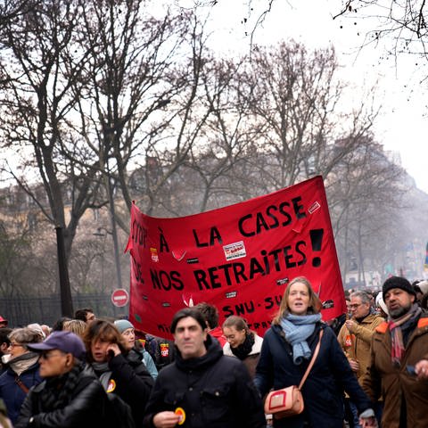 Demonstranten halten ein Transparent mit der Aufschrift "Stoppt die Abschaffung unserer Renten" (Foto: dpa Bildfunk, picture alliance/dpa/AP | Christophe Ena)