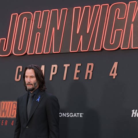 Der Schauspieler steht bei der Hollywood-Premiere von John Wick: Kapitel 4 vor dem gleichlautenden Plakat (Foto: IMAGO, IMAGO / Starface)