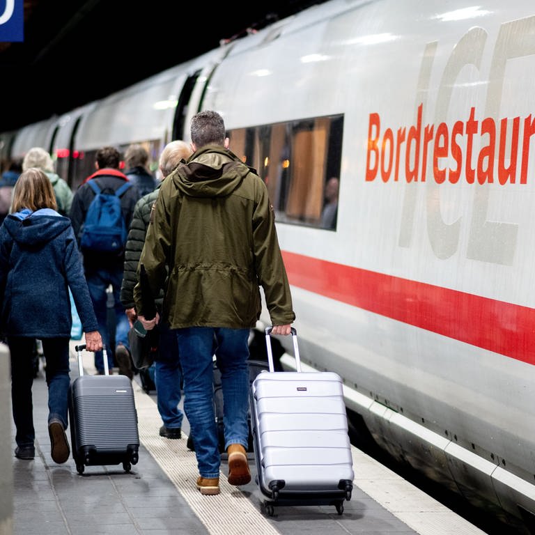 Fahrgäste gehen am frühen Morgen mit ihrem Gepäck über einen Bahnsteig am Hauptbahnhof (Foto: dpa Bildfunk, picture alliance/dpa | Hauke-Christian Dittrich)