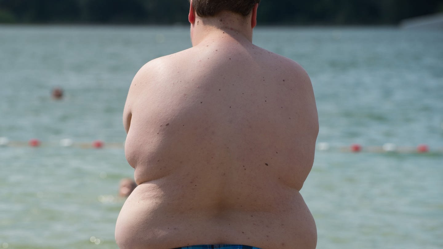 Ein übergewichtiger Junge steht an einem Badesee. Die Arztstudie der Barmer Krankenkasse hat ergeben, dass Kinder immer dicker werden. (Foto: dpa Bildfunk, picture alliance / dpa | Sebastian Kahnert)
