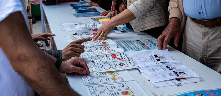 Menschen prüfen Stimmzette der Türkei-Wahl (Foto: dpa Bildfunk, picture alliance/dpa/SOPA Images via ZUMA Press Wire | Murat Kocabas)