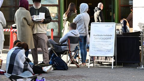 Menschen warten schon Stunden vor der Öffnung vor dem Eingang der Stuttgarter Ausländerbehörde. Die Wartezeiten sind in den letzten Monaten drastisch angestiegen. (Foto: dpa Bildfunk, picture alliance/dpa | Bernd Weißbrod)