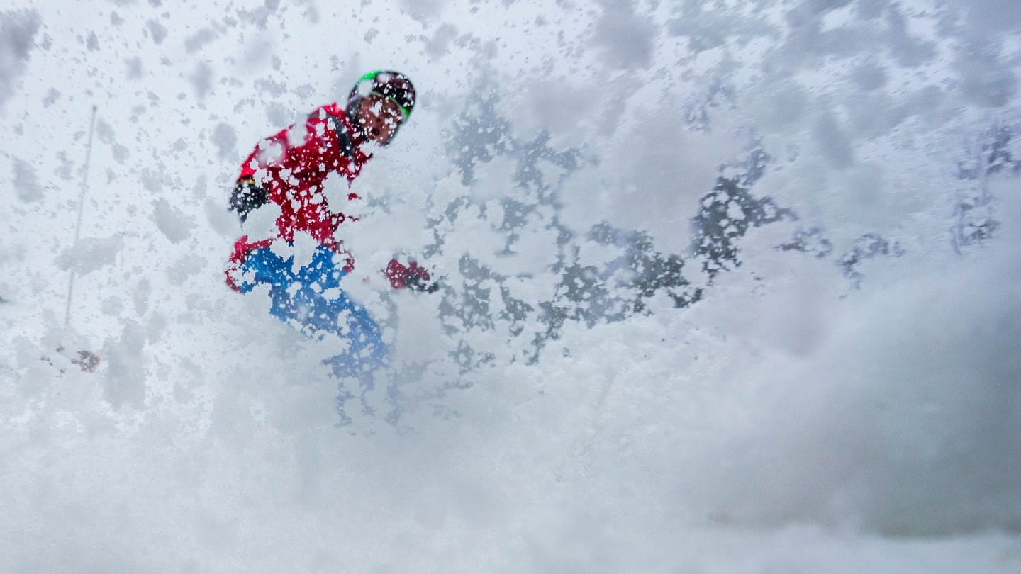 Ein Skifahrer bremst auf der Piste, durch den aufstäubenden Schnee ist er nur schemenhaft zu sehen (Foto: dpa Bildfunk, picture alliance/ dpa/ Frank Rumpenhorst)