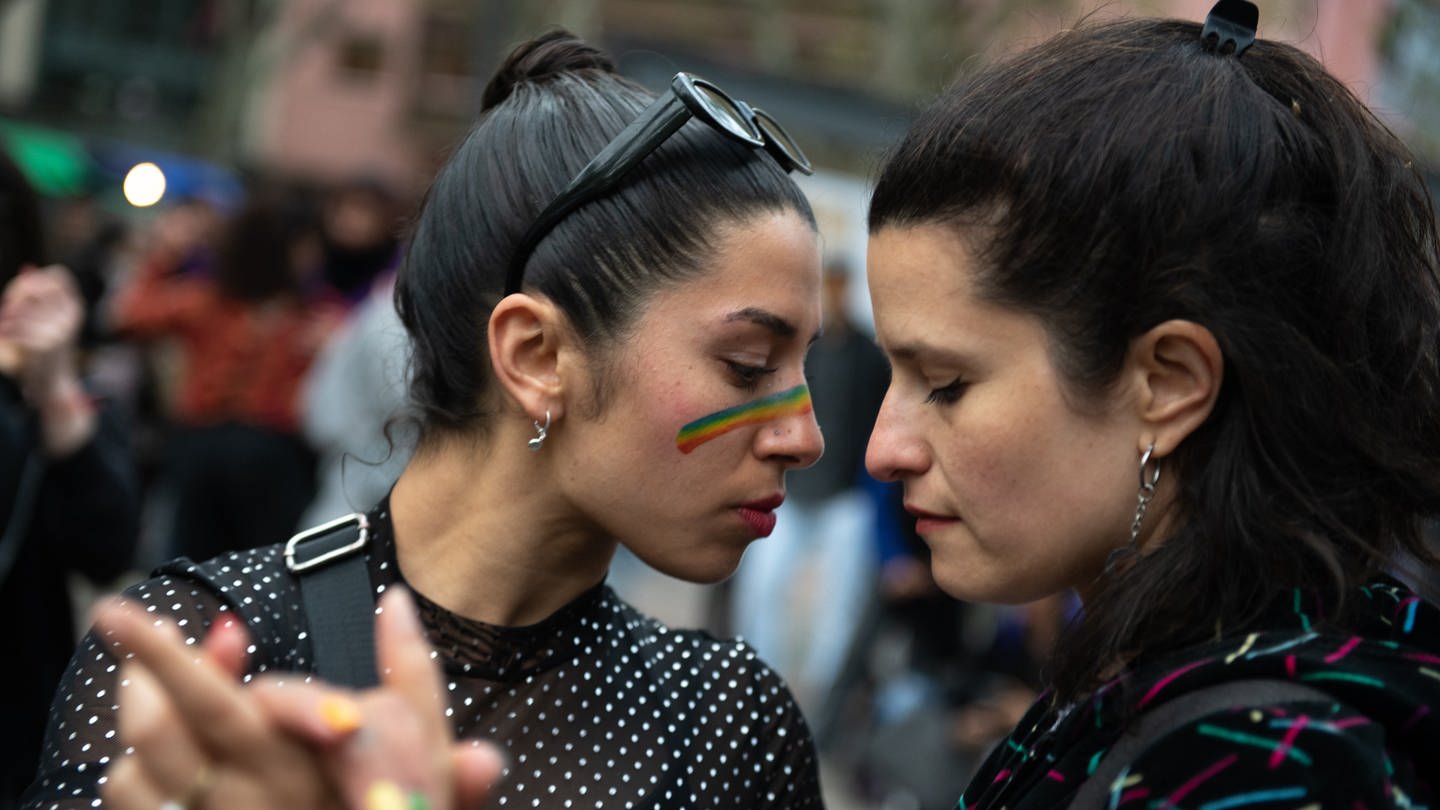 Zwei Teilnehmerinnen tanzen Tango beim Marsch für Vielfalt in der Innenstadt von Montevideo. Jedes Jahr im September ziehen Tausende von Menschen durch die Straßen der Stadt, um auf die Diskriminierung aufgrund der sexuellen Identität und Orientierung aufmerksam zu machen und sie zu bekämpfen. (Foto: dpa Bildfunk, picture alliance/dpa | Santiago Mazzarovich)