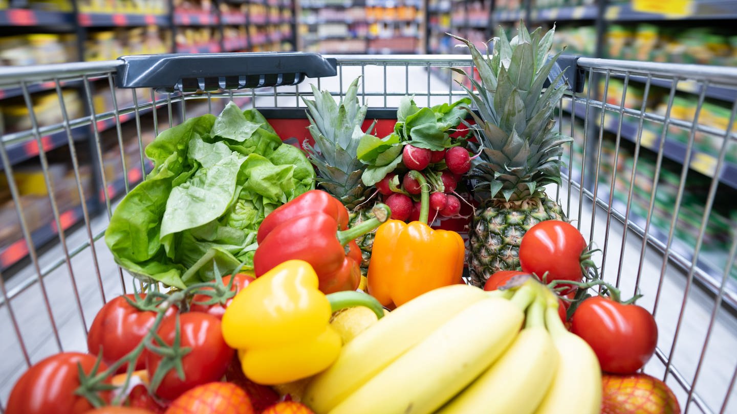 Ein Einkaufskorb mit Obst und Gemüse steht in einem Supermarkt. (Foto: dpa Bildfunk, picture alliance/dpa | Sebastian Kahnert)