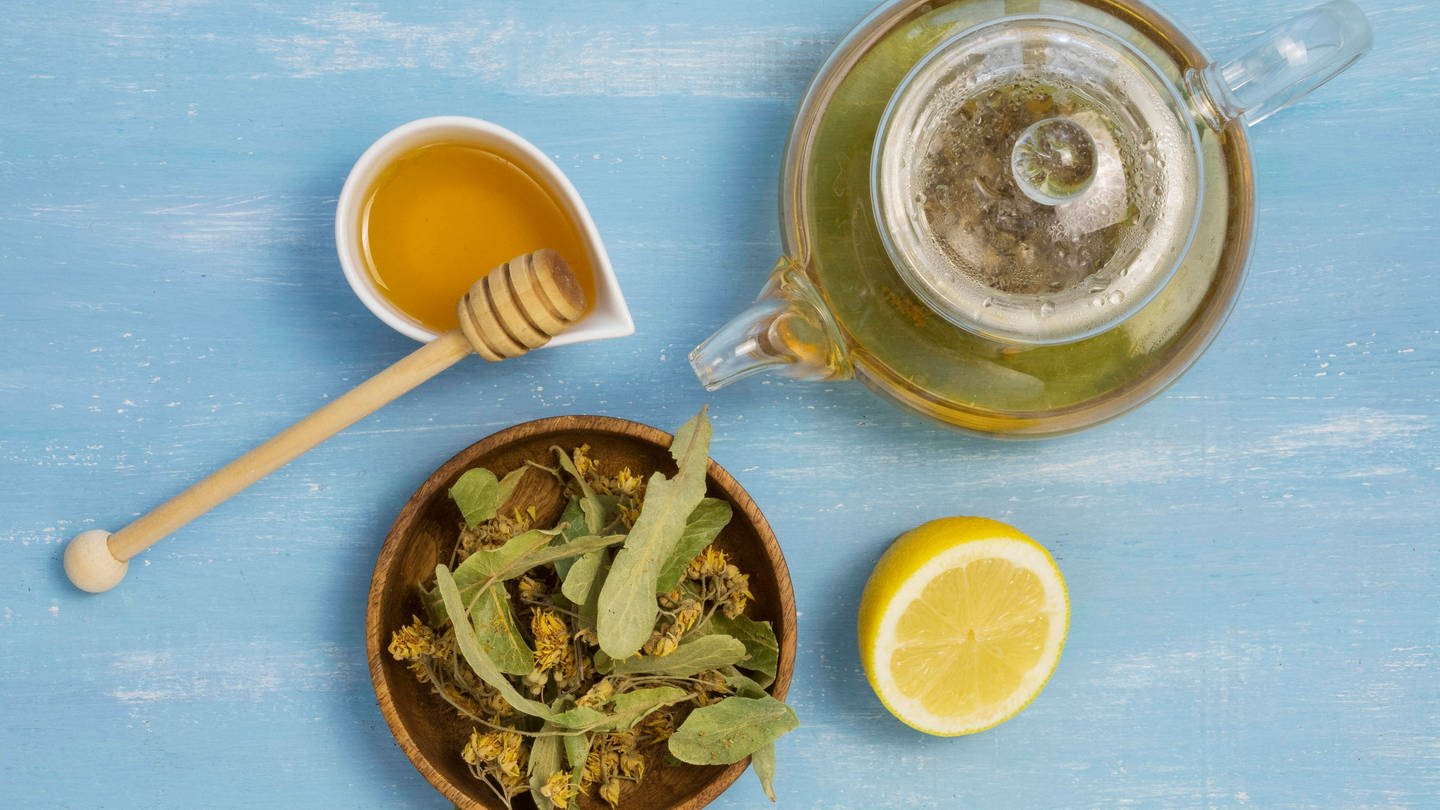 Honig, Zitrone, eine Kanne Tee und eine Heilpflanze (Foto: IMAGO, imageBROKER/OleksandrxLatkun)