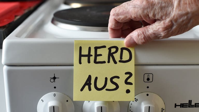 ILLUSTRATION: Demenz - Ein Klebezettel mit dem Schriftzug «Herd aus?» klebt an einem Herd neben den Drehknöpfen.