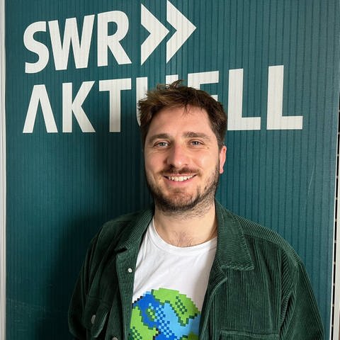 Moritz Braun steht vor dem Logo von SWR Aktuell