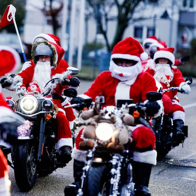 Als Weihnachtsmänner verkleidete Motorradfahrer der Harley Davidson riding Santas fahren über eine Straße. (Foto: dpa Bildfunk, picture alliance/dpa | Uwe Anspach)