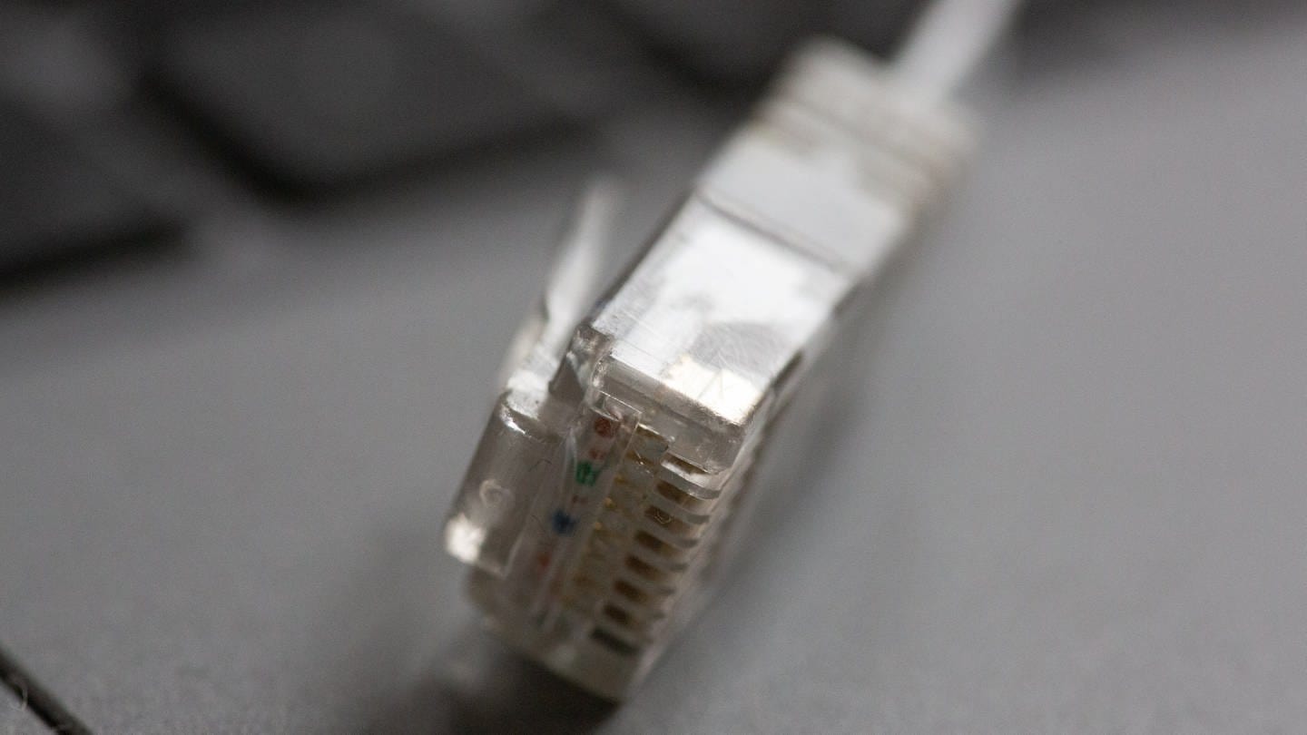 Ein LAN-Kabel liegt auf einem Computerlaptop. (Foto: dpa Bildfunk, Fernando Gutierrez-Juarez)