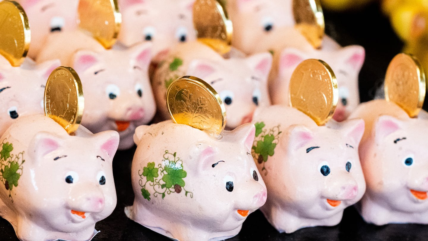 Kleine Schweinchen mit Geldmünzen sind auf einem Stand zum Verkauf für Silvester und Neujahr aufgestellt. Sie sollen Glück, Wohlstand und Reichtum bringen. (Foto: dpa Bildfunk, picture alliance/dpa/APA | Georg Hochmuth)
