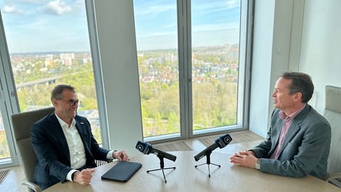 SWR Korrespondent Alfred Schmit und Andreas Schell sitzen gegenüber an einem Tisch in der EnBW Zentrale in Stuttgart  (Foto: EnBW)