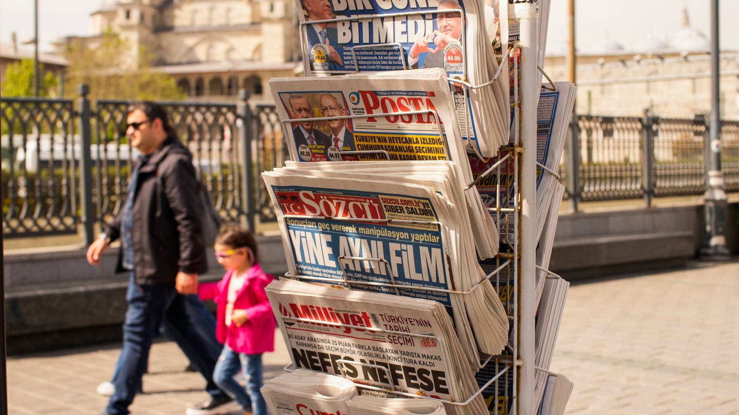 Menschen gehen an einem Zeitungsständer mit türkischen Zeitungen vorbei. (Foto: dpa Bildfunk, picture alliance/dpa/AP | Emrah Gurel)