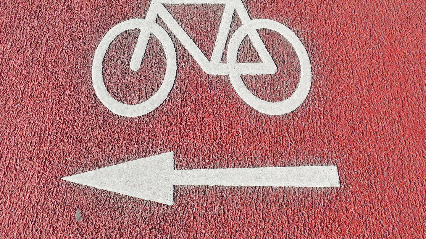 Ein rot markierter Radweg mit einem weißen Fahrradsymbol (Foto: IMAGO, IMAGO/ imagebroker/ Torsten Krüger)