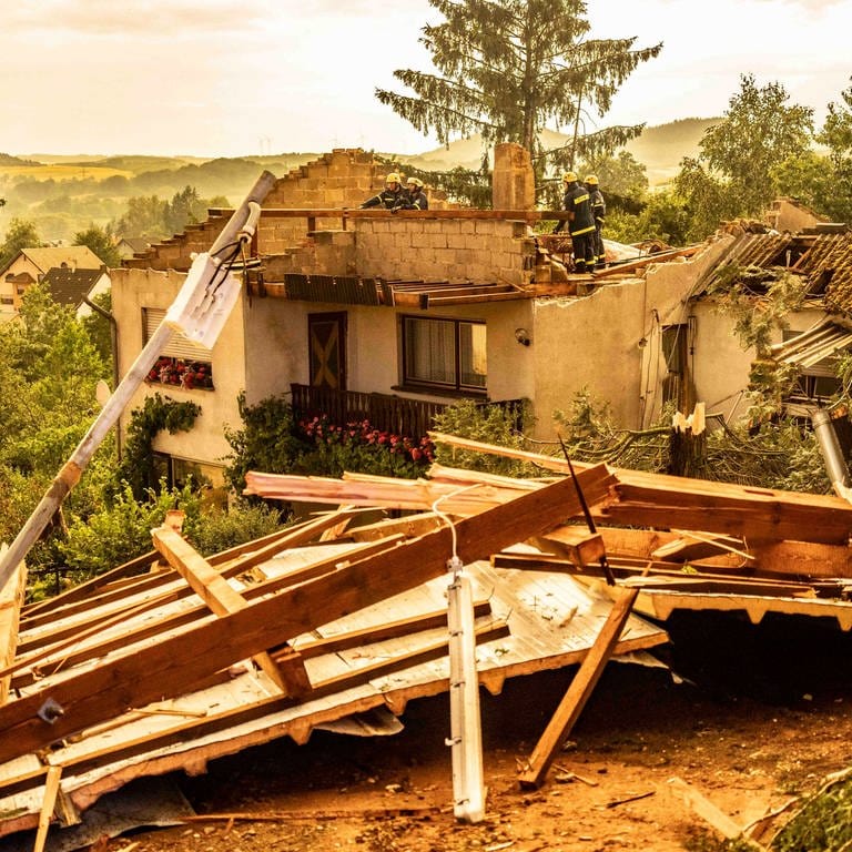 Rettungskräfte arbeiten an einem zerstörten Haus, dessen Dach von einem Sturm abgedeckt wurde. Ein Sturm hat am Dienstagabend in der Gemeinde Freisen im Saarland gewütet. Ob es sich um einen Tornado handelte, war zunächst noch unklar.