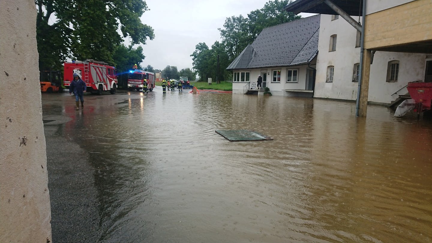 Eine Dorfstraße in Österreich ist überschwemmt, die Feuerwehr pumpt Wasser ab (Foto: dpa Bildfunk, picture alliance/ dpa/ BFV DEUTSCHLANDSBERG/ APA)
