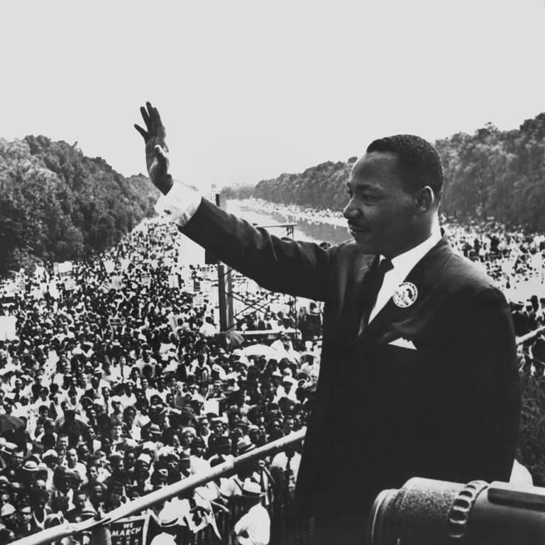 ARCHIV - 28.08.1963 , USA, Washington:  Martin Luther King winkt am 28.08.1963 von der Lincoln Gedächtnisstätte in Washington (USA) den Demonstranten zu. (Foto: dpa Bildfunk, picture alliance / dpa/dpa | dpa)